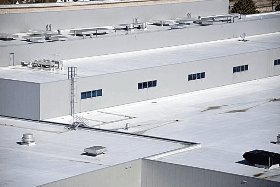 White industrial buildings with flat roofs and five windows