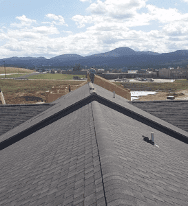 On top of a roof looking off toward distant mountains with a city at the base