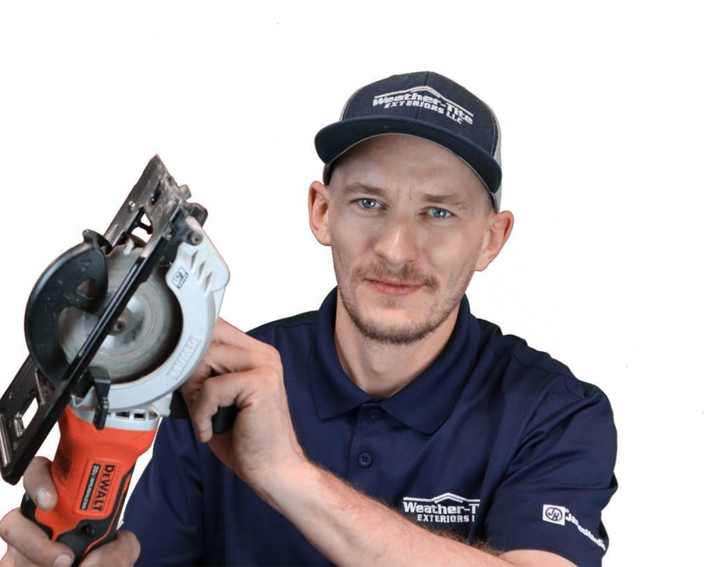 man with a short brown beard wearing a weather tite shirt and hat holding a power saw