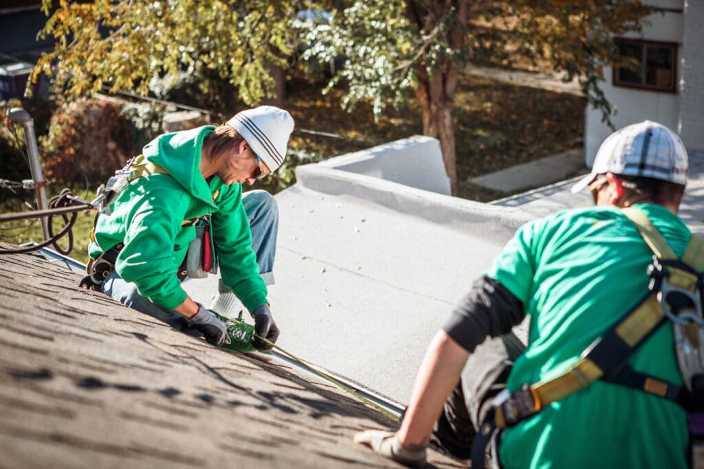 Two-Roofers-Inspecting-the-Shingles-on-a-roof-and-documenting-damages